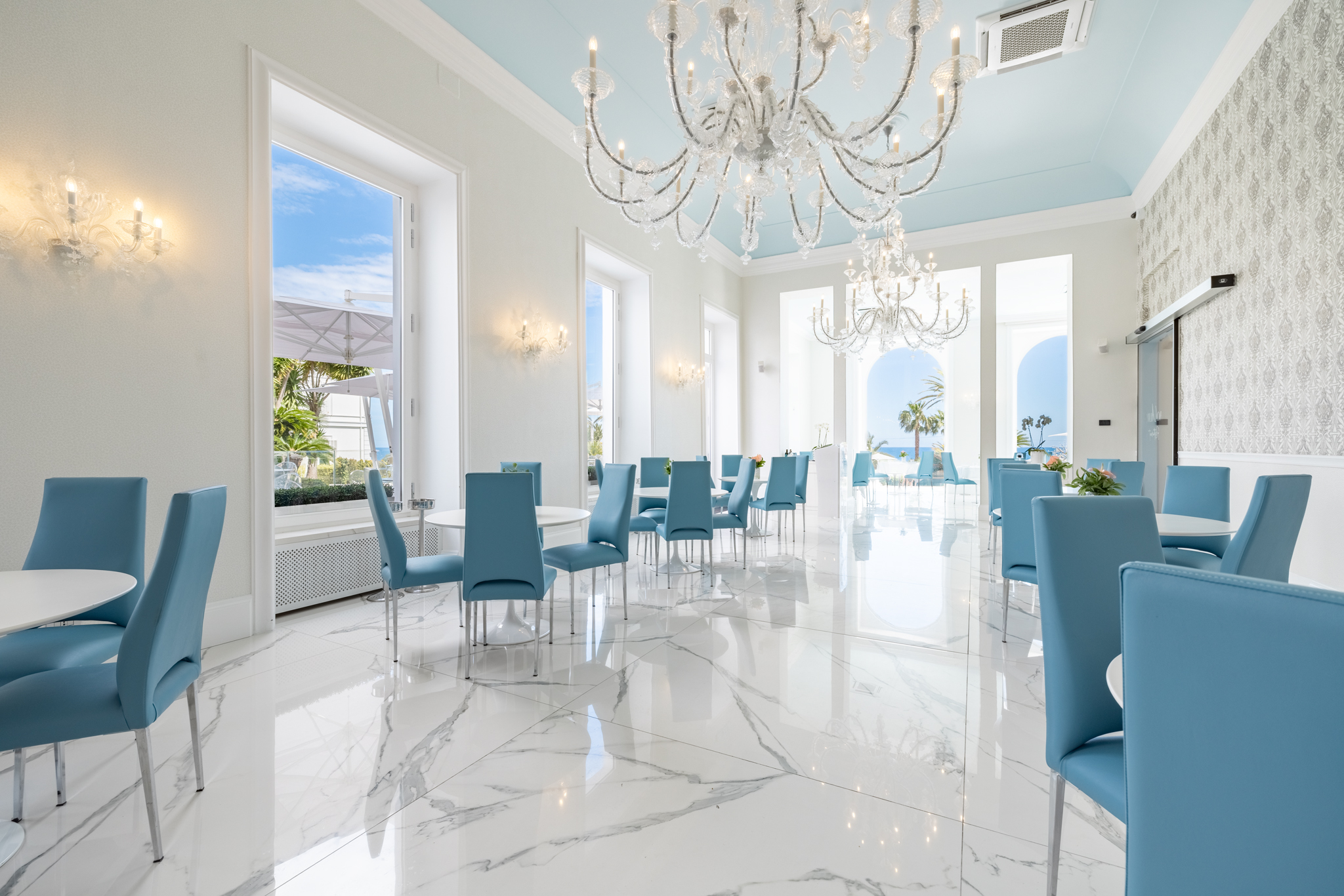 Sala Aqualua luminosa con lampadari e vista mare